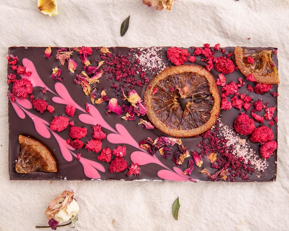 Lagusta's Luscious' famous Valentine’s bark. Each vegan chocolate bar is handmade with frills and hearts in our pink white chocolate. Delicately decorated with candied oranges and dried fruits.