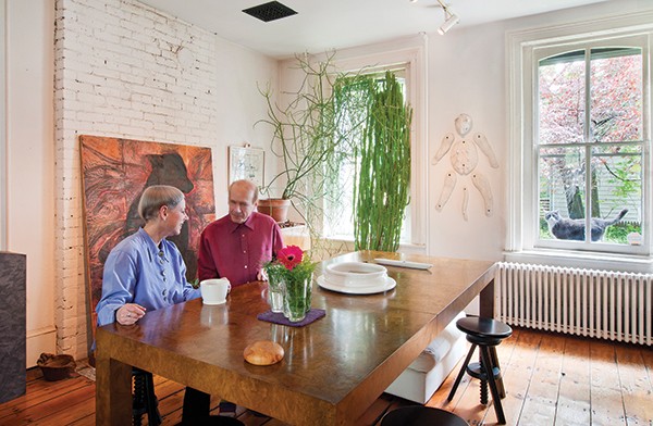 Jan Harrison and Alan Baer in their dining room, with a feline named Sox in the window.