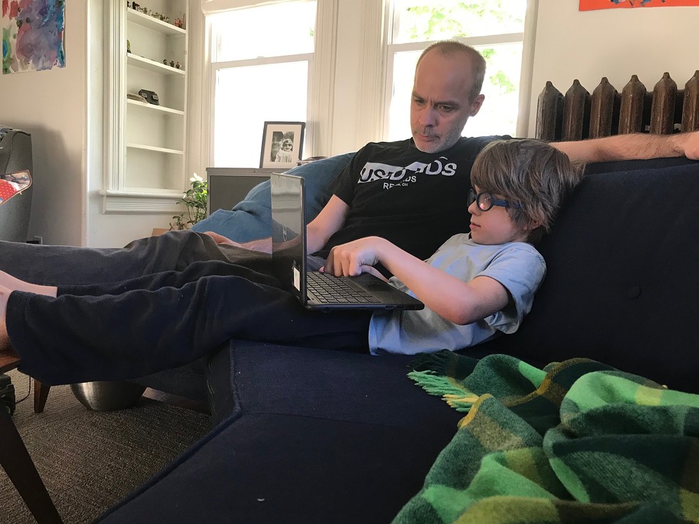 Finnegan Zellinger and his father, Jim Zellinger, work on Finnegan's assignments at home.