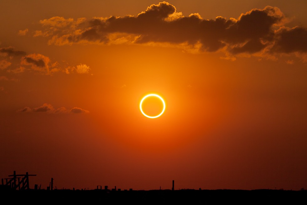 Mid-solar eclipse, perfectly centered ring of fire at sunset.